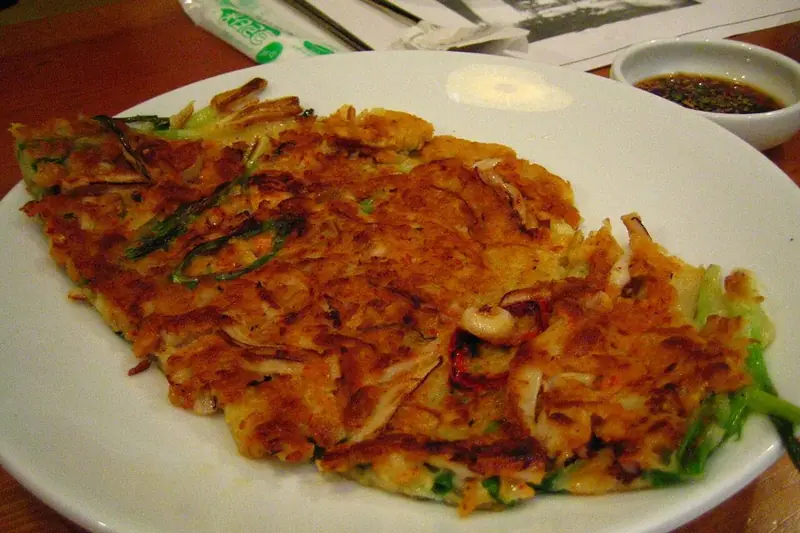 Golden mung bean pancake (bindaetteok) with vegetables on a plate