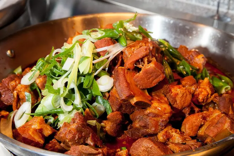 Spicy jjimgalbi braised beef ribs topped with scallions