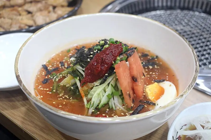 Kimchi-mari-guksu, cold noodles in kimchi broth topped with egg and kimchi