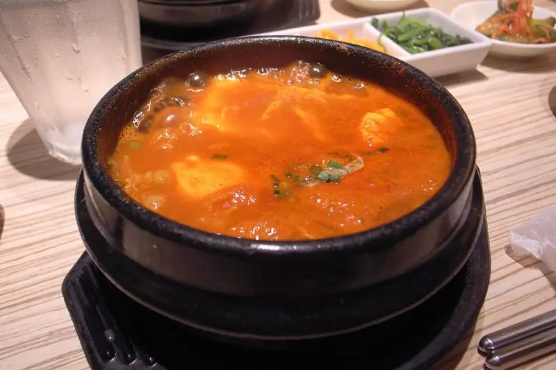 Bubbling sundubu-jjigae soft tofu stew in a stone pot