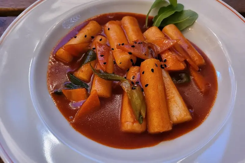 Tteokbokki rice cakes in red spicy gochujang sauce on a plate